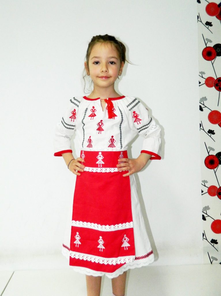 Fetita in tinuta traditionala cu broderie rosie